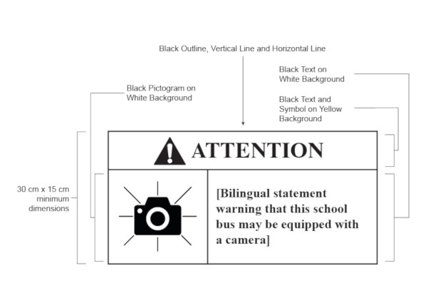 White rectangle with black border, text, lines and symbols. At the top of the rectangle above a horizontal line: a triangle with an exclamation mark centered in it and, to the right of the triangle, the word “ATTENTION”. Below the horizontal line: a camera to the left of a vertical line and, to the right of the vertical line, in brackets, the words “Bilingual statement warning that this school bus may be equipped with a camera”.